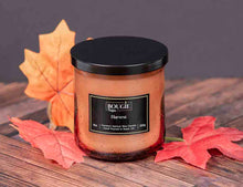 Load image into Gallery viewer, Candle labeled 'Bougie Napa Harvest' with autumn leaves on a wooden surface