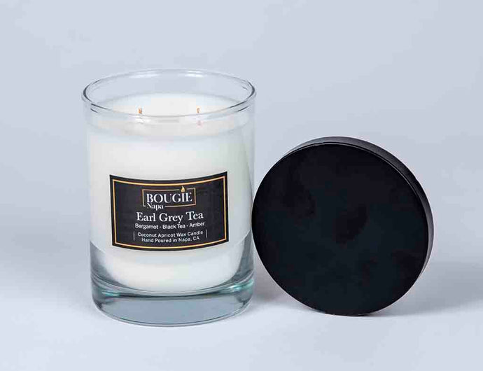 Glass candle with a black lid on a light gray background