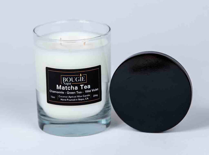 Matcha Tea candle in a glass jar with a black lid on a white background