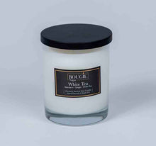 Load image into Gallery viewer, Candle in a glass jar with a black lid and label on a light gray background
